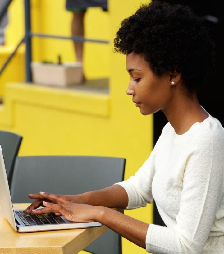 attractive-young-woman-using-laptop-outside-P9RLFGU-min